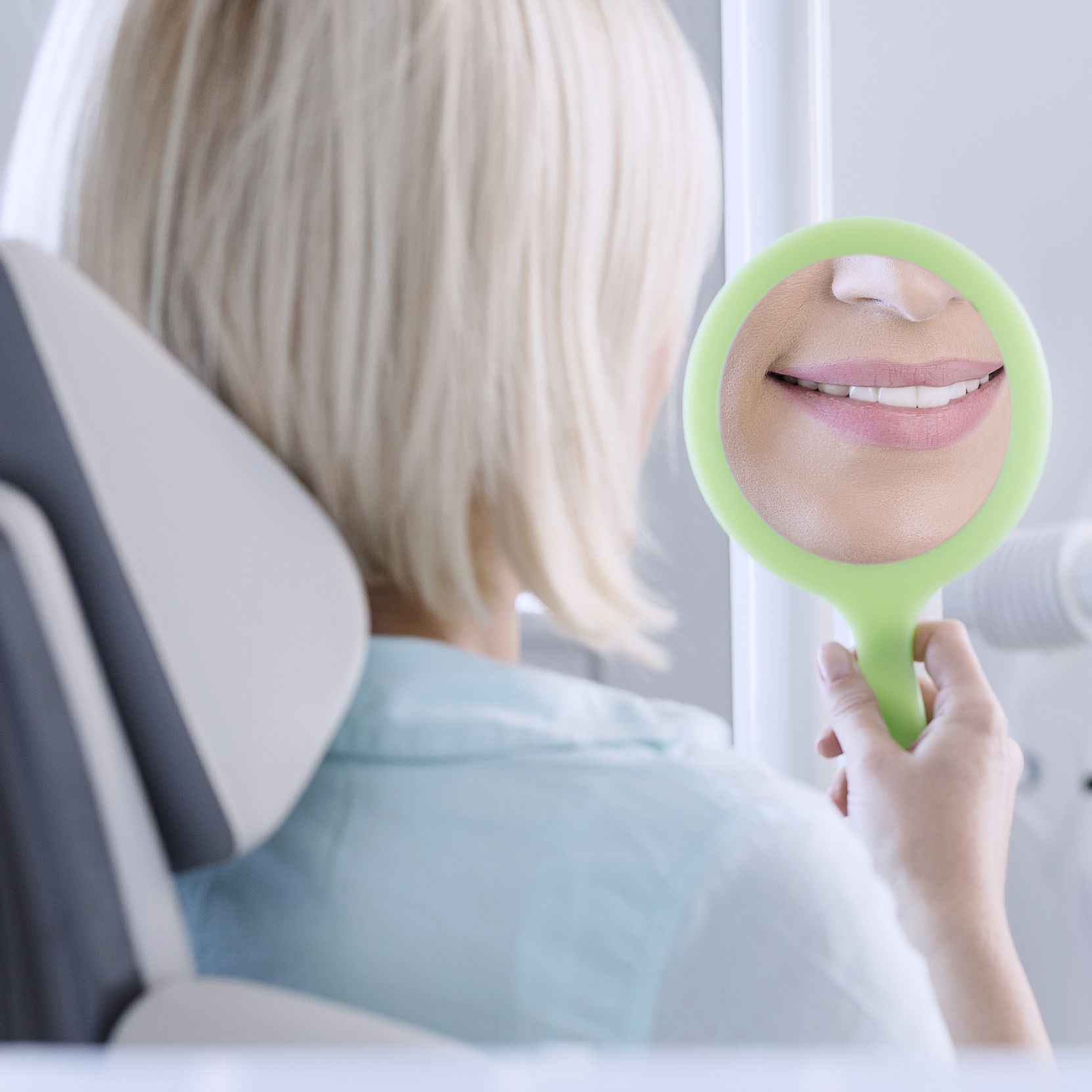 A woman looking at her teeth in the mirror